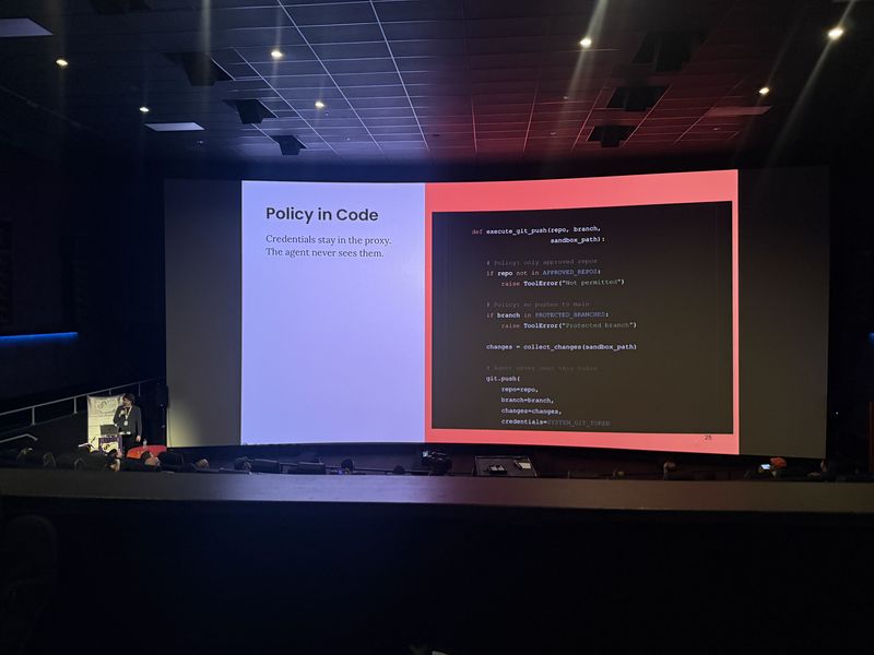 Slide: Policy in Code shows a Python proxy function that checks approved repos, blocks protected branches, and injects credentials the agent never sees